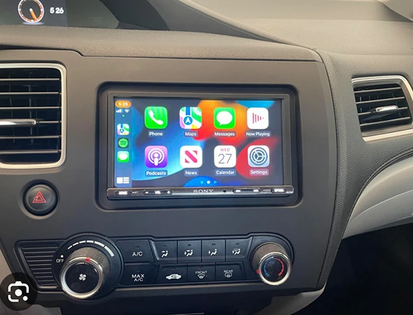 Car dashboard with a touchscreen displaying app icons and controls, set in a modern vehicle interior. The tone is sleek and high-tech.